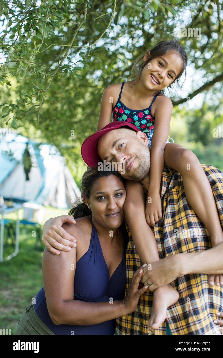 Ritratto felice, affettuosa famiglia al campeggio Foto Stock