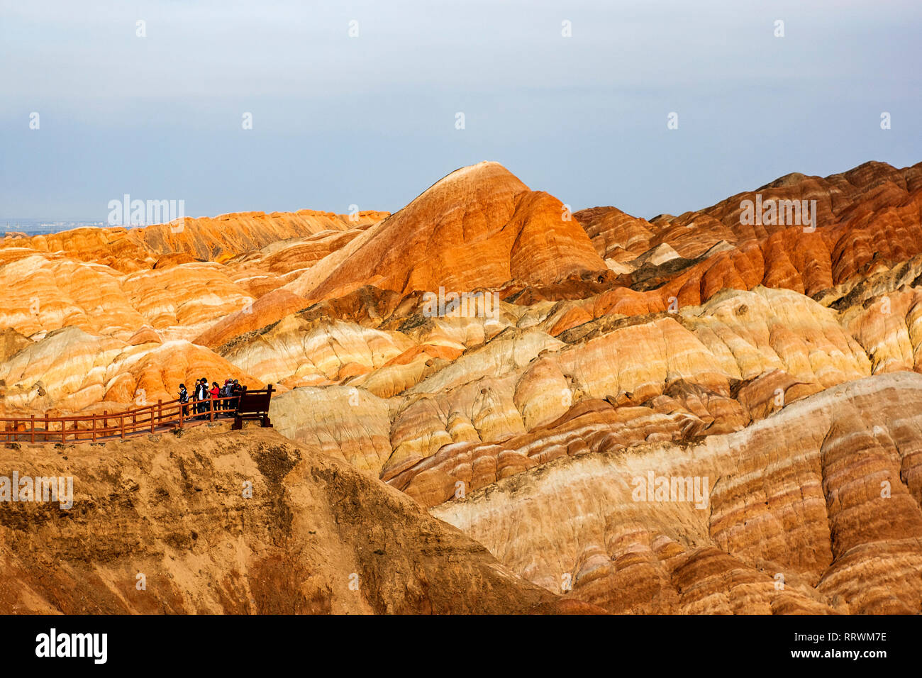 I turisti cinesi sono nella piattaforma di osservazione e la sommità del Rainbow Montagne parco geologico. Striata Danxia Zhangye rilievi parco geologico nel Gansu Foto Stock