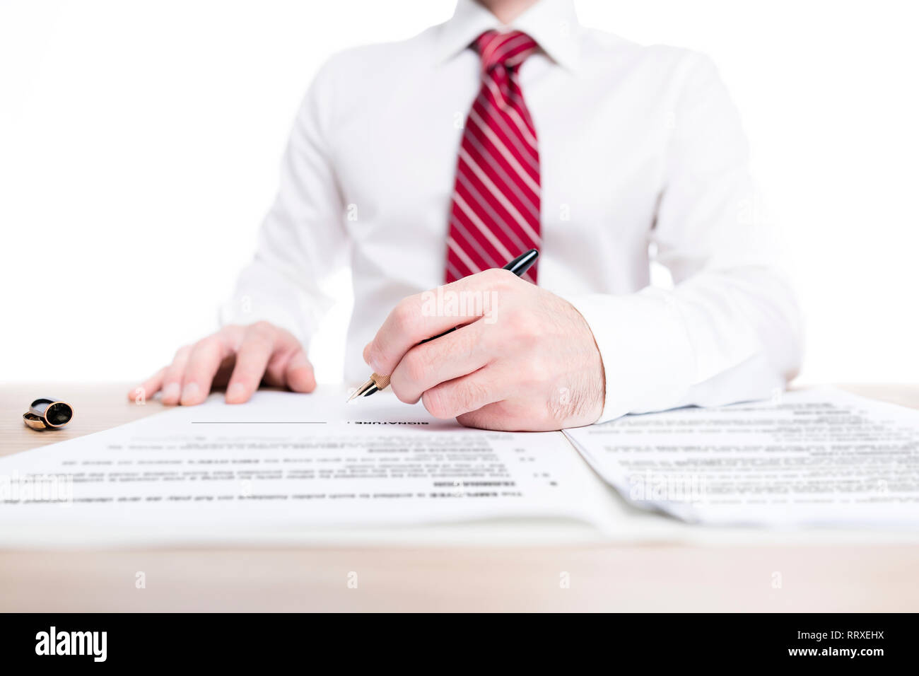 Imprenditore in camicia e cravatta firma un contratto di carta con una penna stilografica su una scrivania Foto Stock