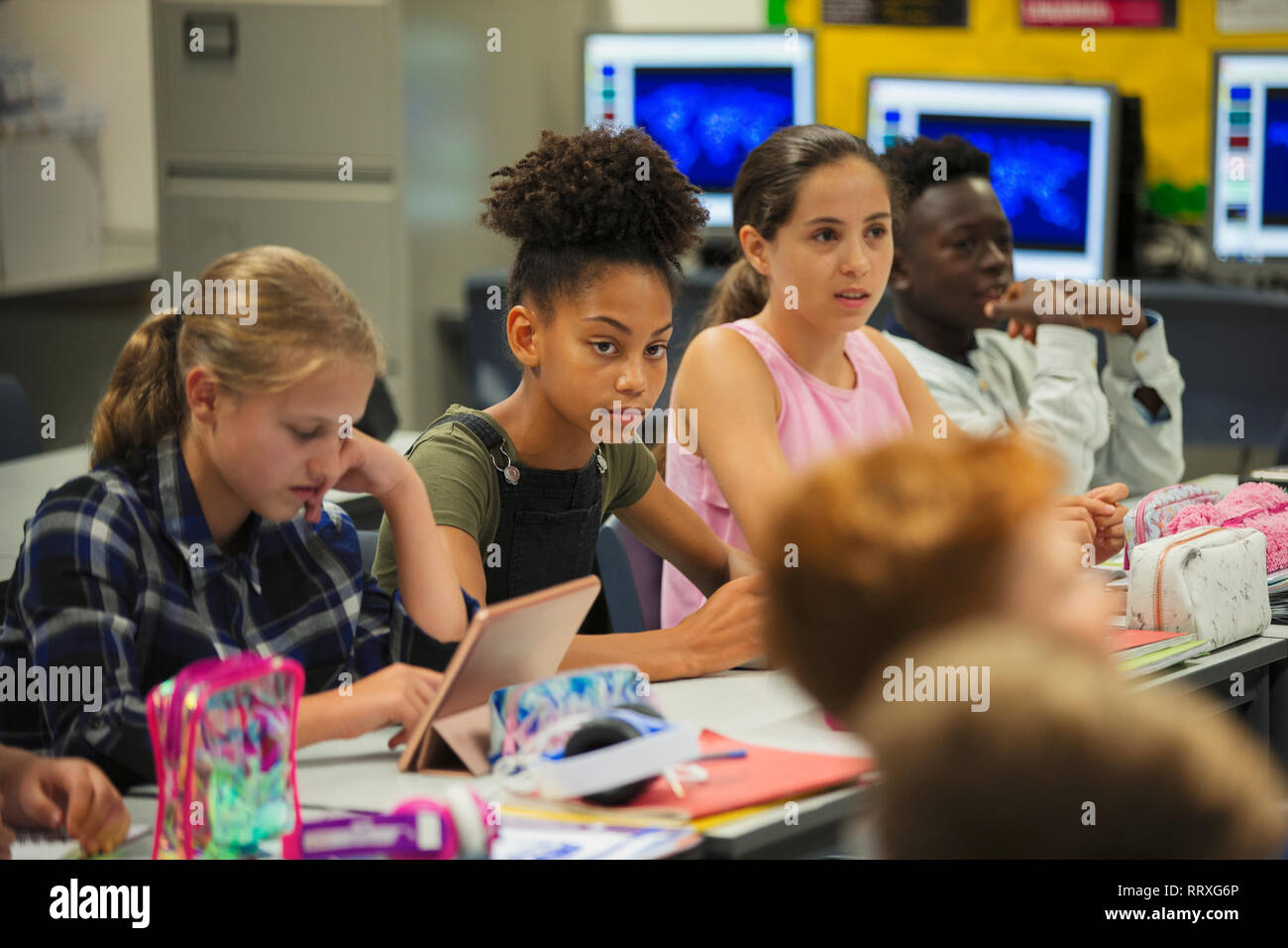 Focalizzato junior high school girl ascolto dello studente in aula Foto Stock
