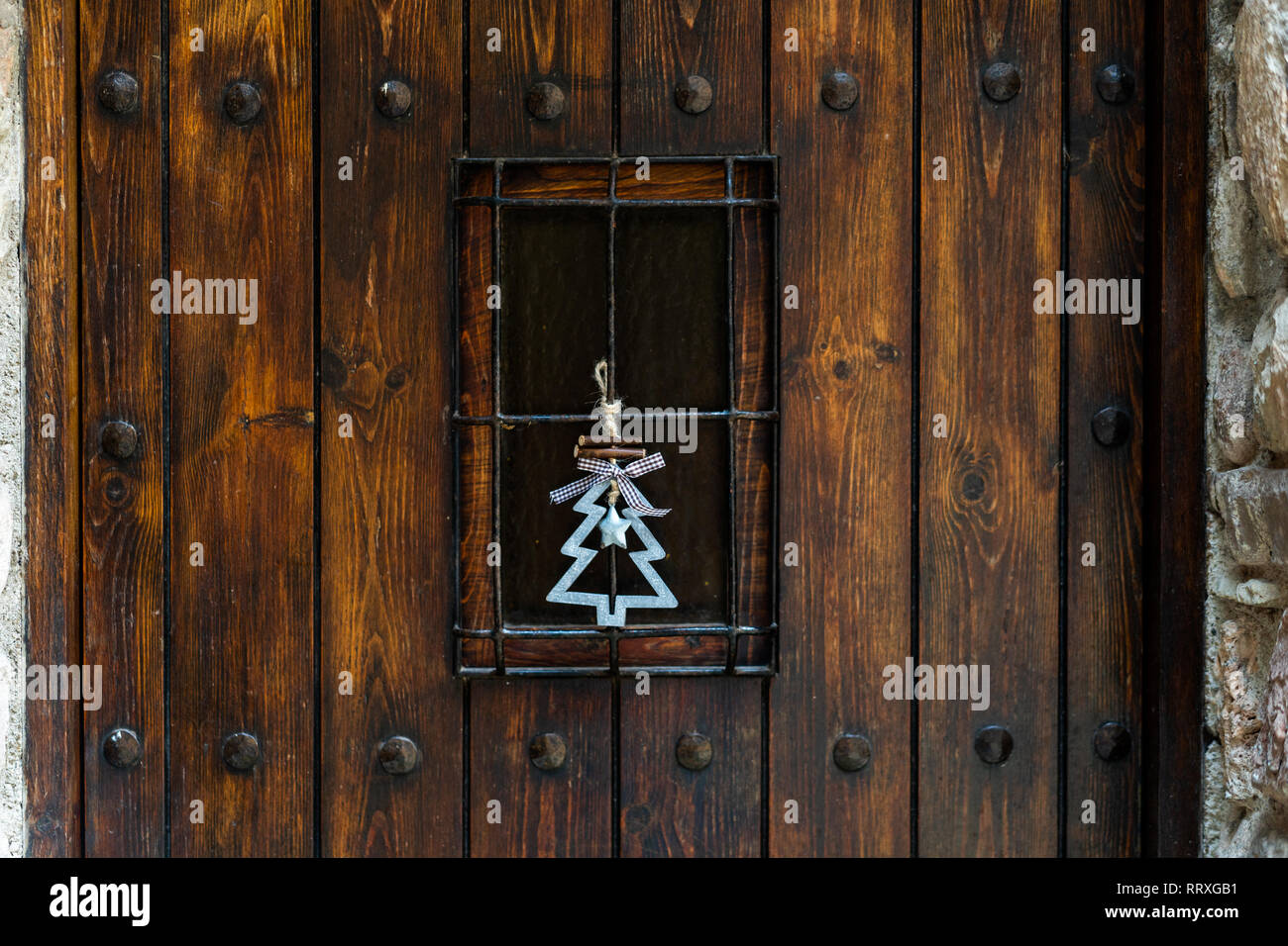 Decorativo Closeup abete con banda e stella appesa sul vecchio grunge porta in legno Foto Stock