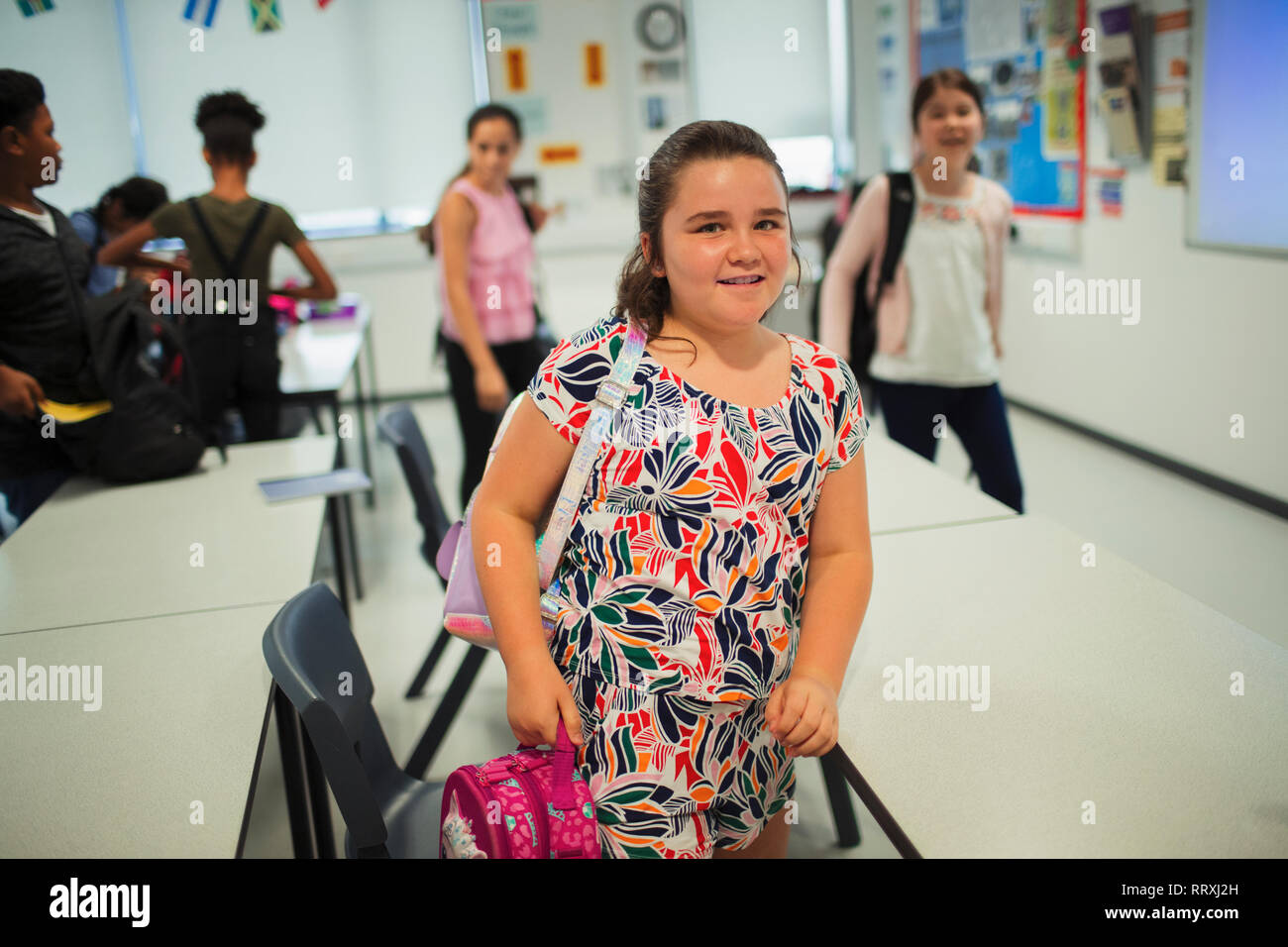 Ritratto fiducioso junior high school girl studente lasciando classroom Foto Stock