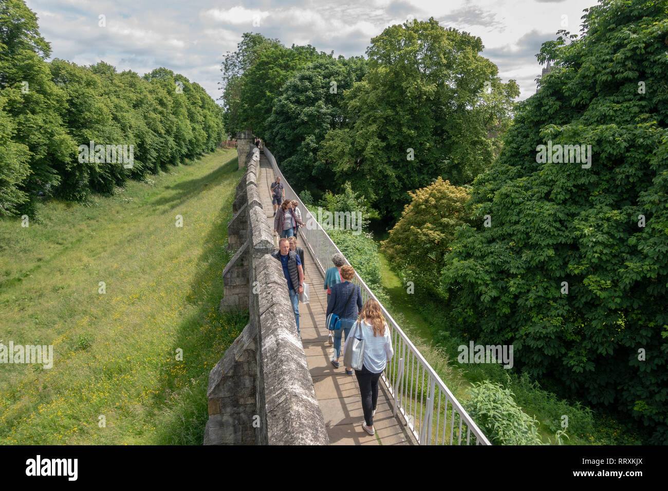 I visitatori a piedi su un tratto delle mura romane a nord del centro della città di York, nello Yorkshire, Regno Unito. Foto Stock