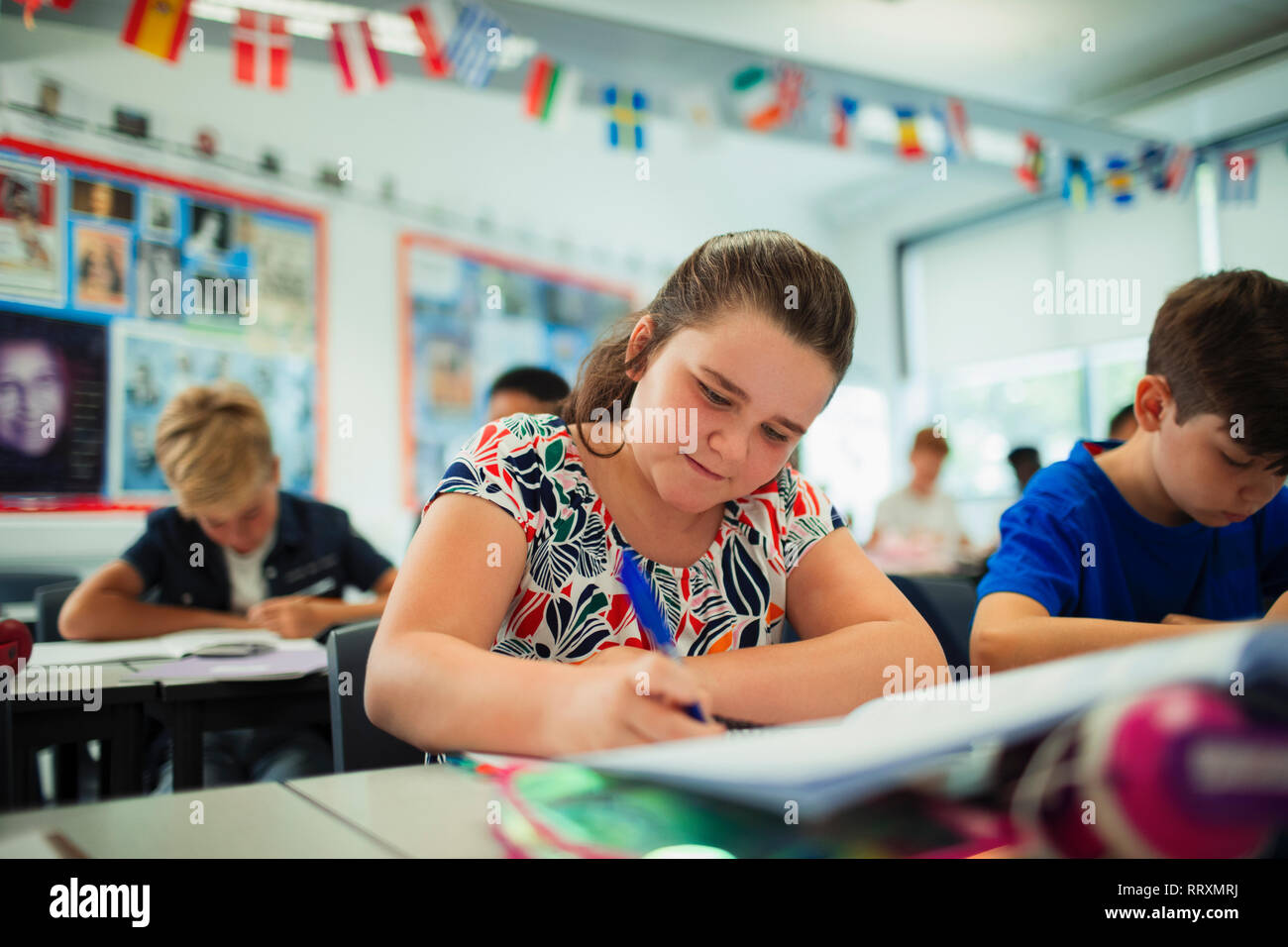 Focalizzato junior high school girl studente facendo i compiti in classe Foto Stock