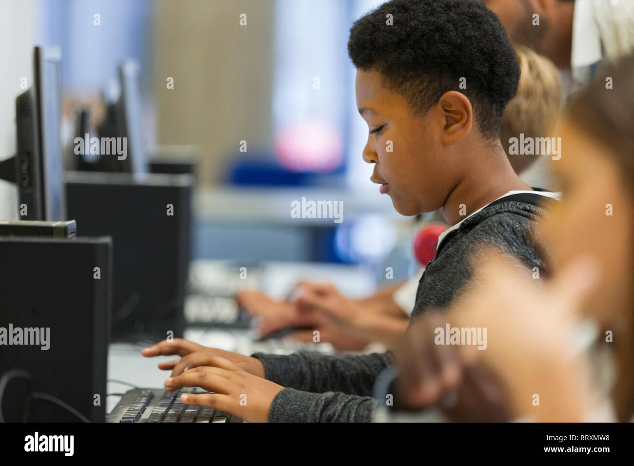 Focalizzato junior alto ragazzo studente utilizzando computer in laboratorio informatico Foto Stock