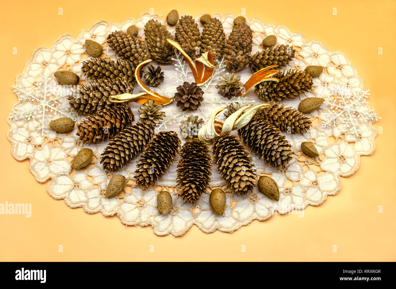 Tovagliolo ricamato su sfondo giallo con un telaio di forma ovale con un pattern di coni di diverse razze, fiocchi di neve, scorza di arancia e mandorla ed sull' Foto Stock