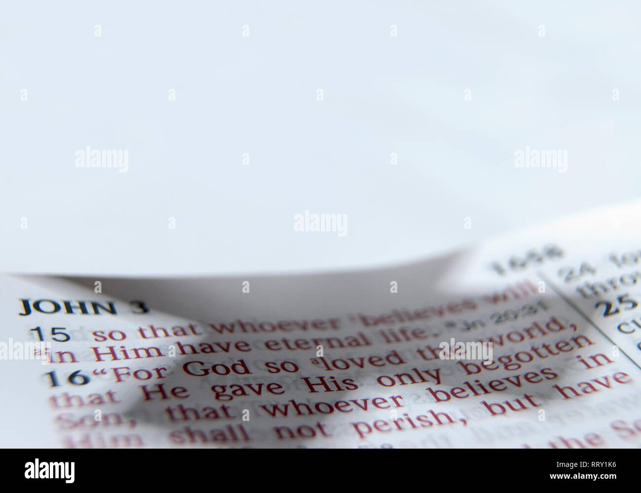 Primo piano di Giovanni 3:16 versetto biblico del testo per la Pasqua con croce ombra. Foto Stock