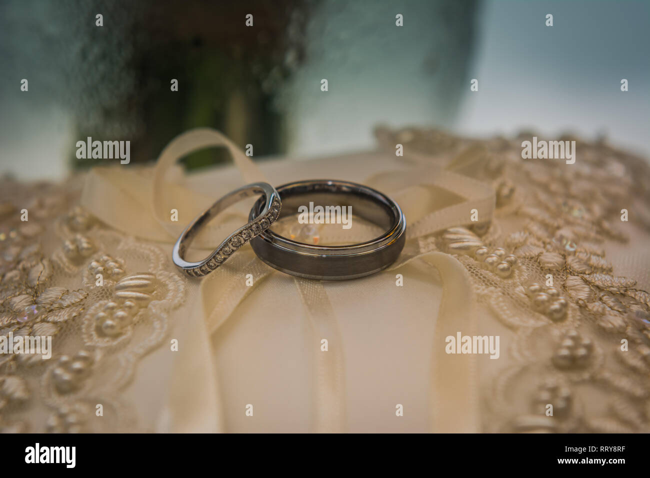 Gli anelli di nozze su una perla ricoperto abito da sposa Foto Stock