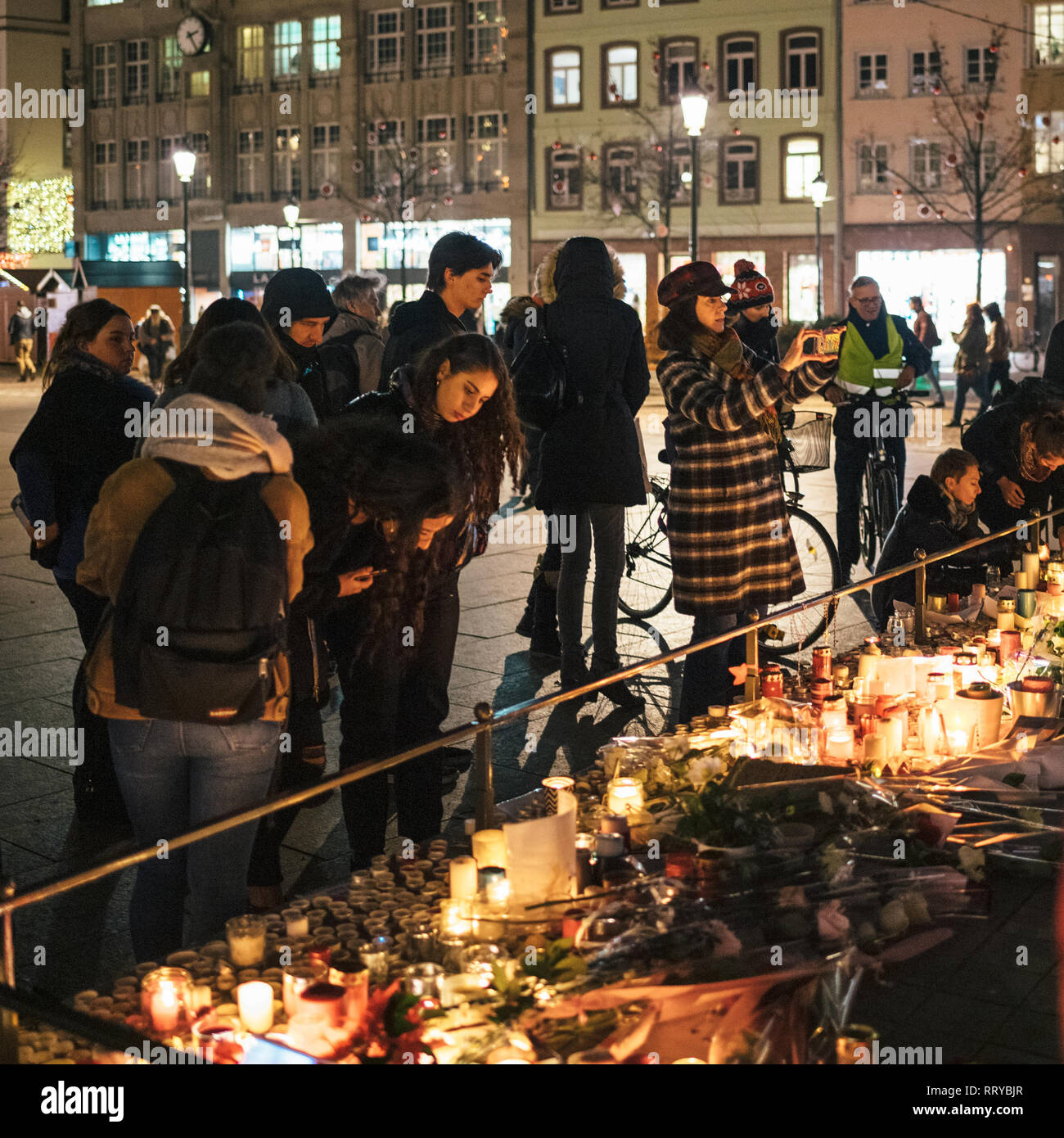 Strasburgo, Francia - Dic 13, 2018: vista laterale di persone in lutto radunati nelle vicinanze del Kleber generale statua a partecipare a una veglia con più luce di candele fiori e messaggi per le vittime degli attentati Cherif Chekatt al mercatino di Natale Foto Stock