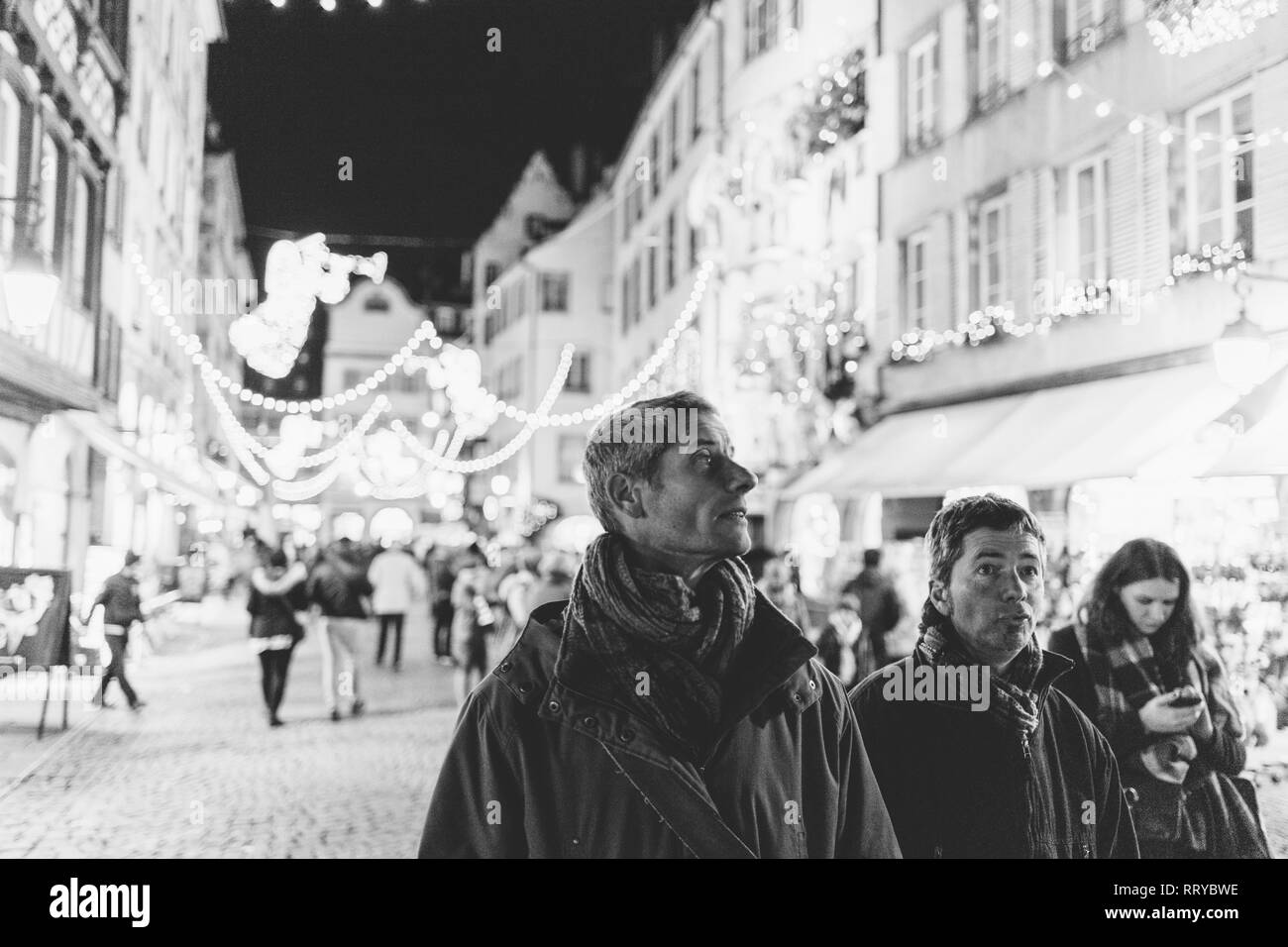 Strasburgo, Francia - Nov 29, 2017: Rue Merciere con visitatori ammirando il splendidamente decorate strade di Strasburgo, capitale di Natale in Europa - negozi e persone nello sfondo - bianco e nero Foto Stock