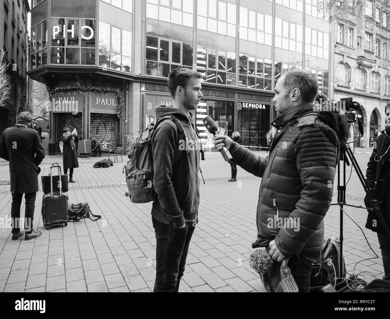 Strasburgo, Francia - Dic 11, 2018: Giornalista parlando con il francese giovane uomo dopo l attacco terroristico in Strasbourg Christmas area di mercato Foto Stock