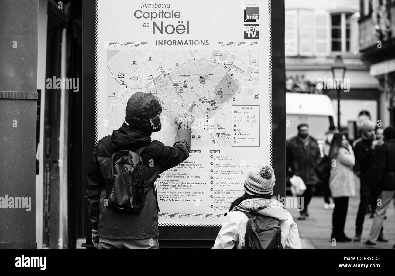 Strasburgo, Francia - Dic 11, 2018: giovani turisti lettura di grandi mappa di Strasburgo la magia di Natale mercato dopo i terroristi di attaccare un giorno prima - Mercato di Natale chiuso Foto Stock