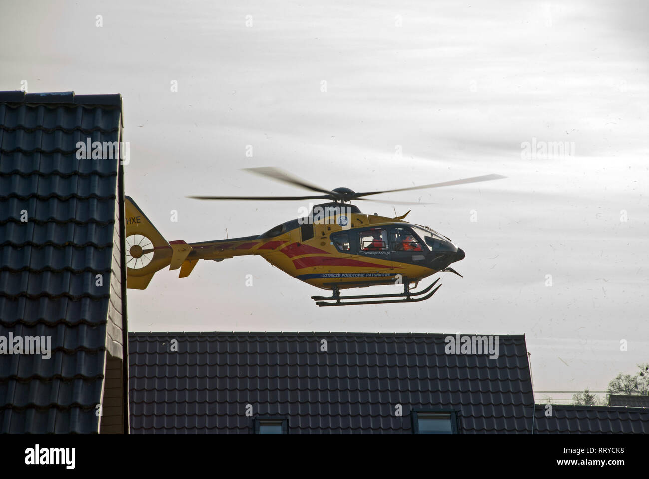 Elicottero del polacco Medical Air Rescue - Lotnicze Pogotowie Ratunkowe. L'elicottero si avvia - sorge sopra i tetti di abitazioni monofamiliari. Foto Stock