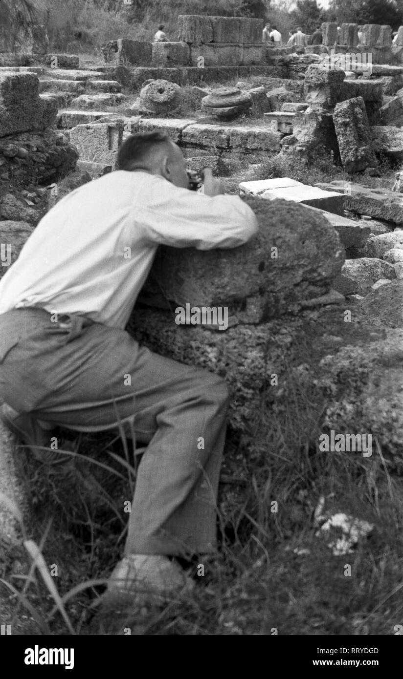 Griechenland, Grecia - Ein Fotograf sucht den besten Winkel, um die Ruinen des antiken Olympia zu fotografieren, Griechenland 1950er Jahre. Un fotografo che cercano il migliore angolo di prendere la sua foto da antica Olympia, Grecia degli anni cinquanta. Foto Stock