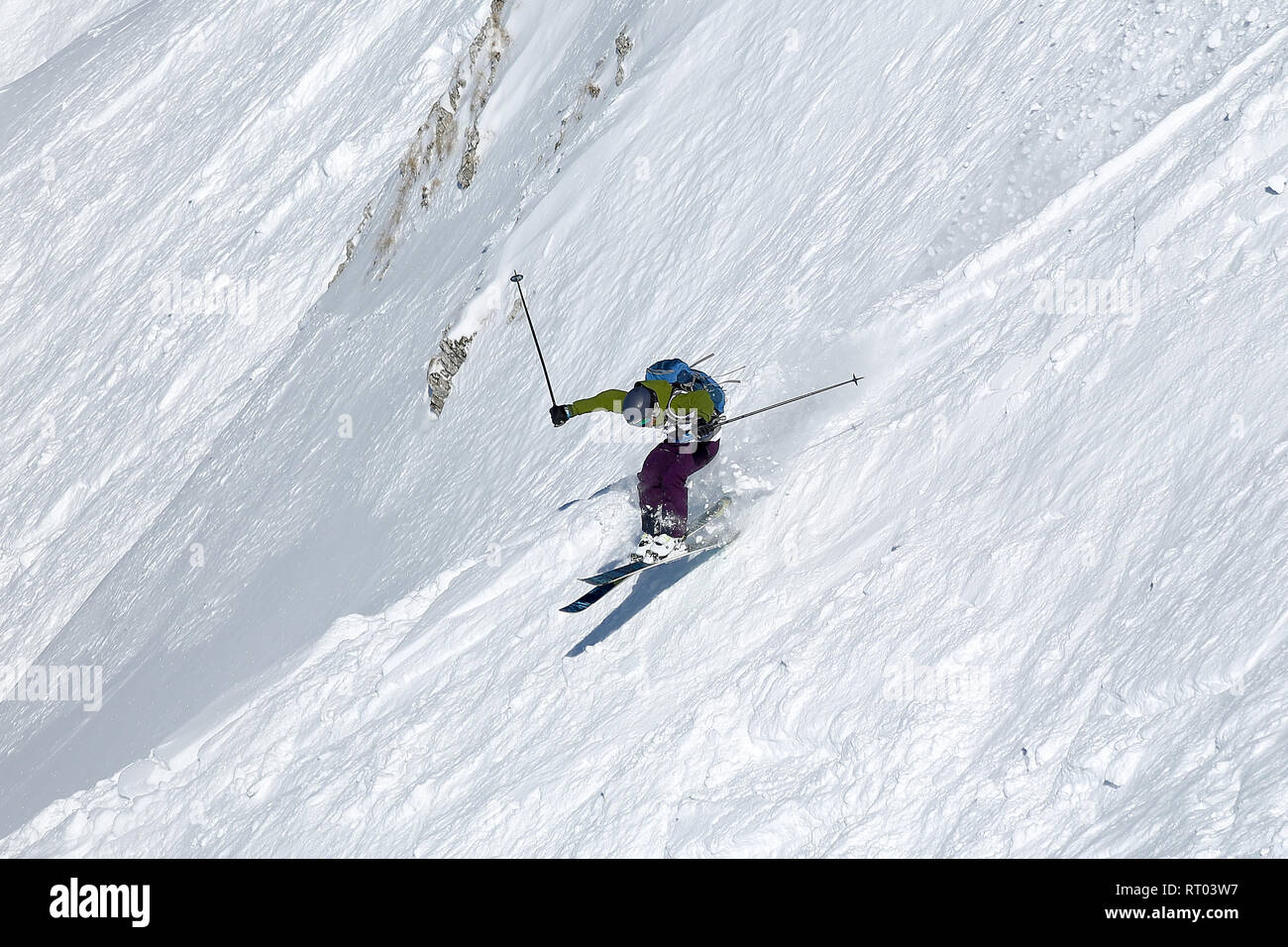 Persona che guida un molto ripide piste da sci in un piccolo salto Foto Stock