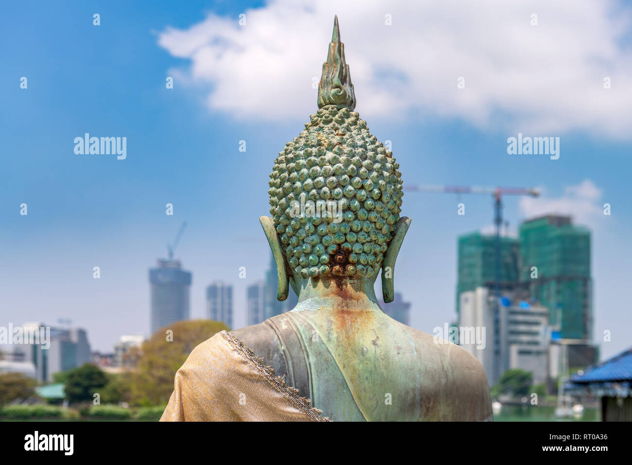 Una statua buddista a Seema Malaka tempio sul lago di Beira si siede in un contesto di sviluppo urbano in Sri Lanka di capitale Colombo. Foto Stock