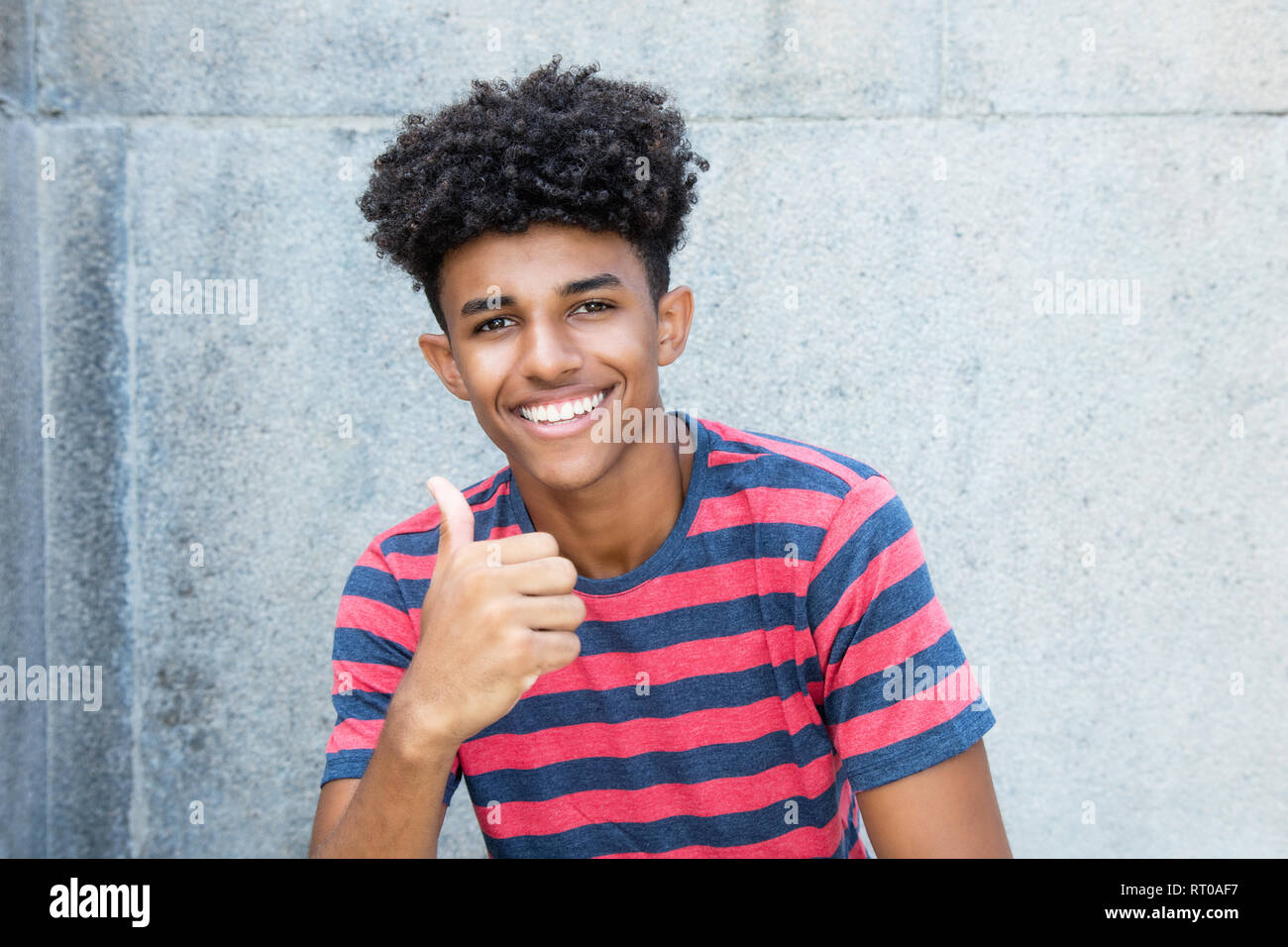 African American giovane uomo adulto che mostra il pollice fino all'aperto in estate Foto Stock