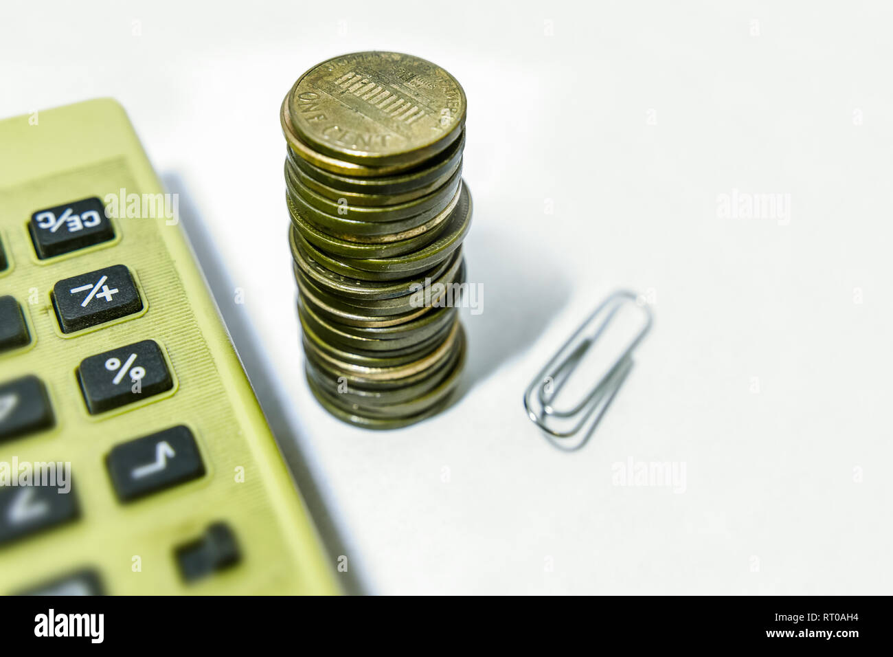 Un mucchio di noi pochi spiccioli, retromarcia fino, a deformata di pinzatura e di una calcolatrice obsoleti, tutte sotto un tetro luce. Spazio di copia Foto Stock