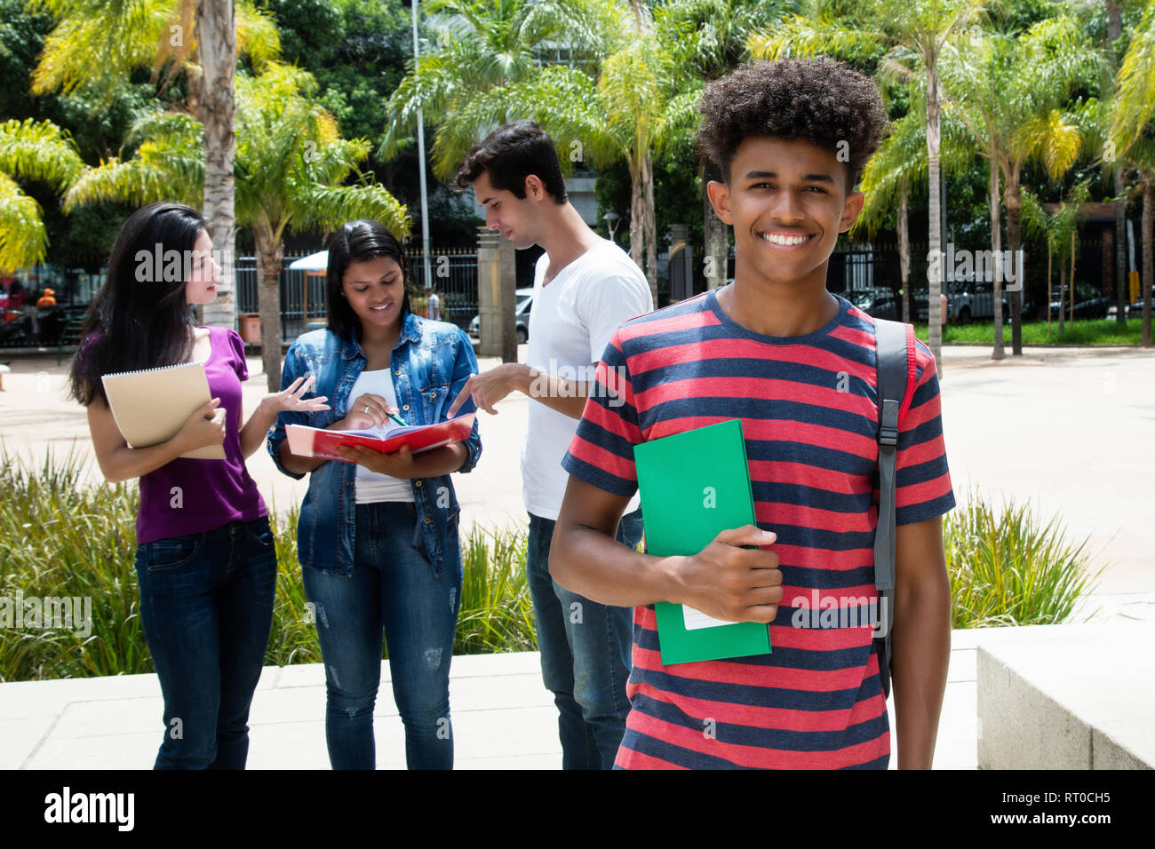 Americano africano studente maschio con un gruppo di altri studenti internazionali all'esterno sul campus della unniversity Foto Stock