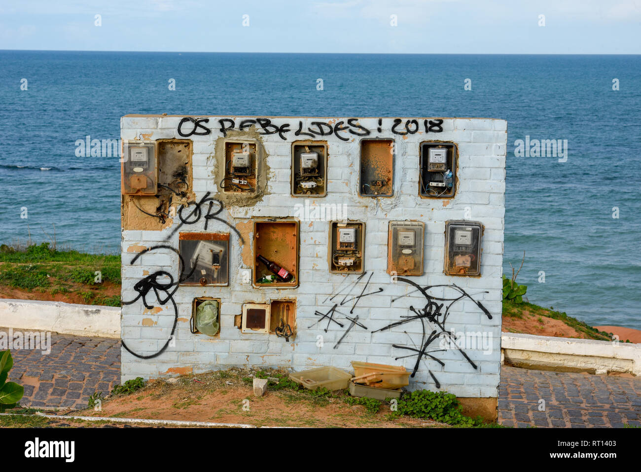 Vecchio e rotto contatore elettrico scatole su una parete di fronte al mare in Brasile Foto Stock