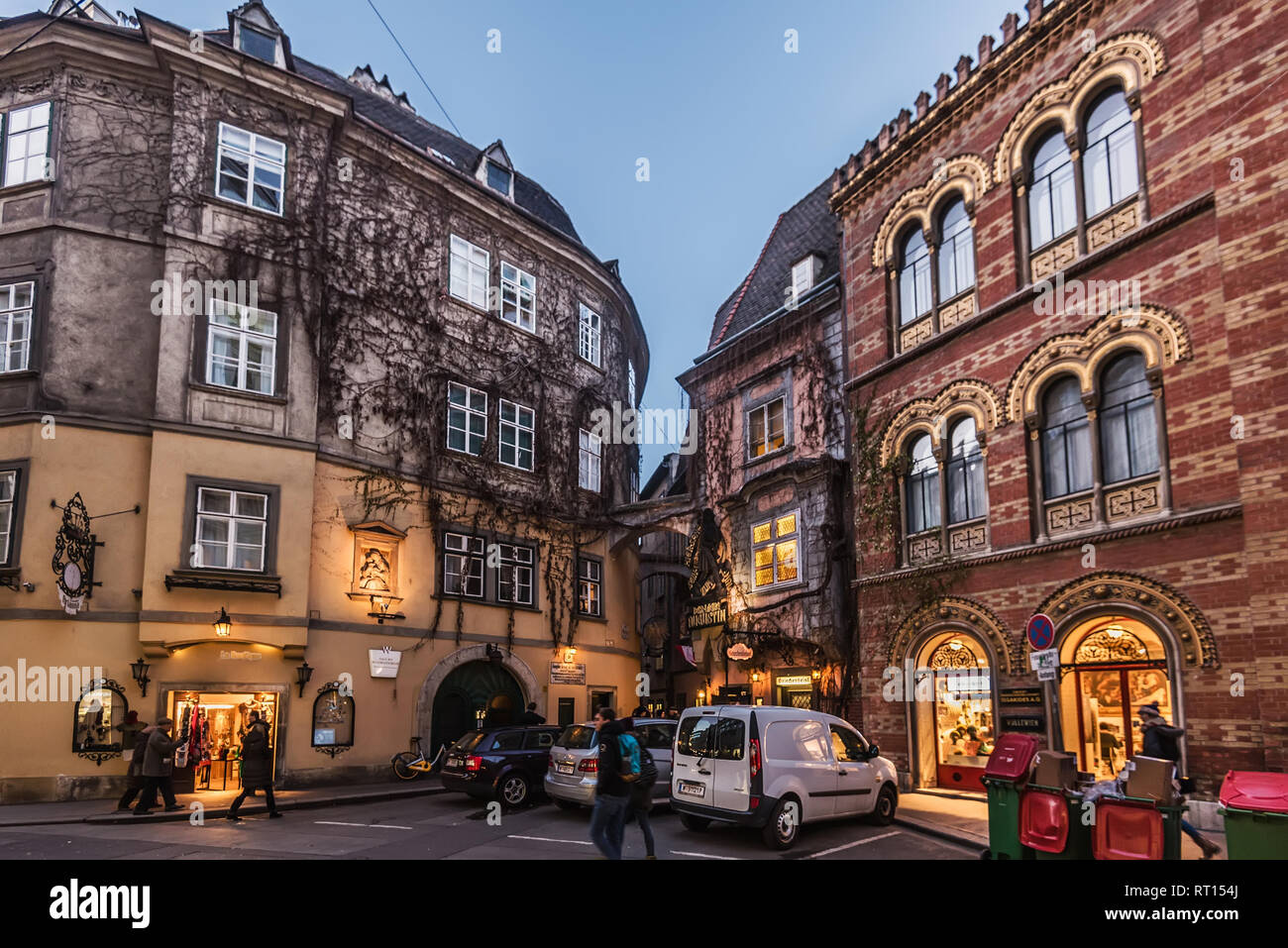 Vienna, Austria - 29 dicembre 2017. Città vecchia strada viennese con facciate di edifici, negozi, automobili parcheggiate, persone a piedi, illuminazione di vetrine e Griech Foto Stock