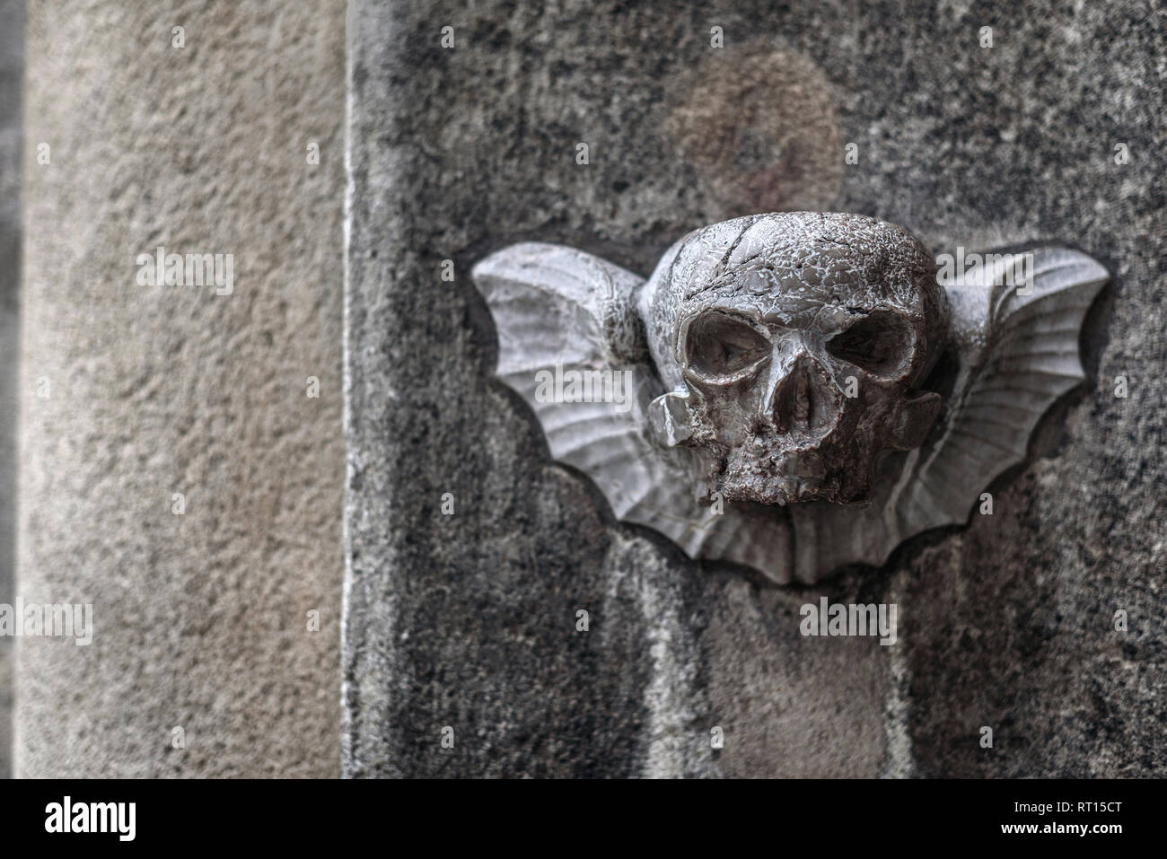 Vienna, Austria - 30 dicembre 2017. Pietra scolpita scull con ali sulla vecchia chiesa parete di facciata. Decorative in bassorilievo la scultura raffigura la mortalità alato Foto Stock