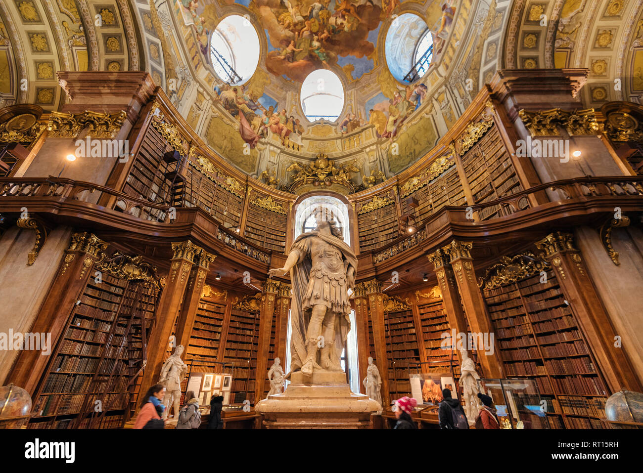 Vienna, Austria - 24 dicembre 2017. Interno della Biblioteca Nazionale Austriaca con l'imperatore Carlo VI statua. Impero asburgico della vecchia libreria barocca Grand ha Foto Stock