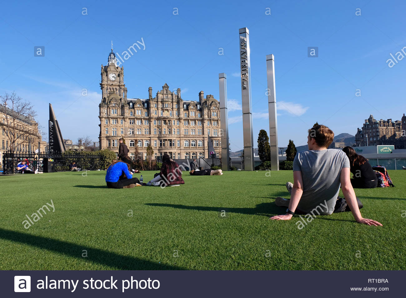 Edinburgh, Regno Unito. Il 27 febbraio 2019. Le persone che si godono il sole in Waverley Mall giardino con il Balmoral Hotel. Credito: Craig Brown/Alamy Live News Foto Stock