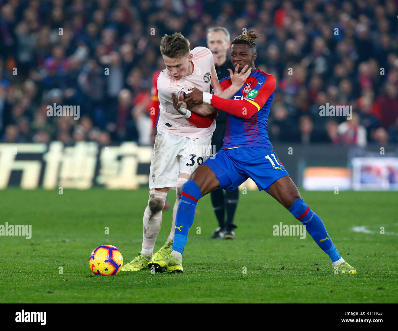 Londra, Regno Unito. Il 27 febbraio, 2019. Il Manchester United McTominary Scott e Crystal Palace di Wilfried Zaha durante la Premier League inglese tra Crystal Palace e il Manchester United a Selhurst Park Stadium di Londra, Inghilterra il 27 Feb 2019. Credit: Azione Foto Sport/Alamy Live News Foto Stock