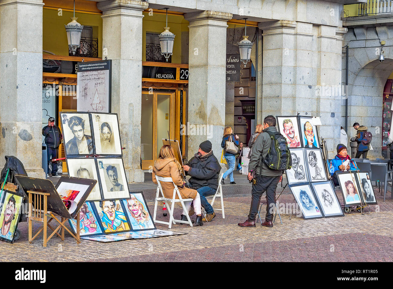 Il 22 gennaio 2019. Plaza Mayor di Madrid. Un disegnatore di strada facendo un ritratto di una donna. Foto Stock