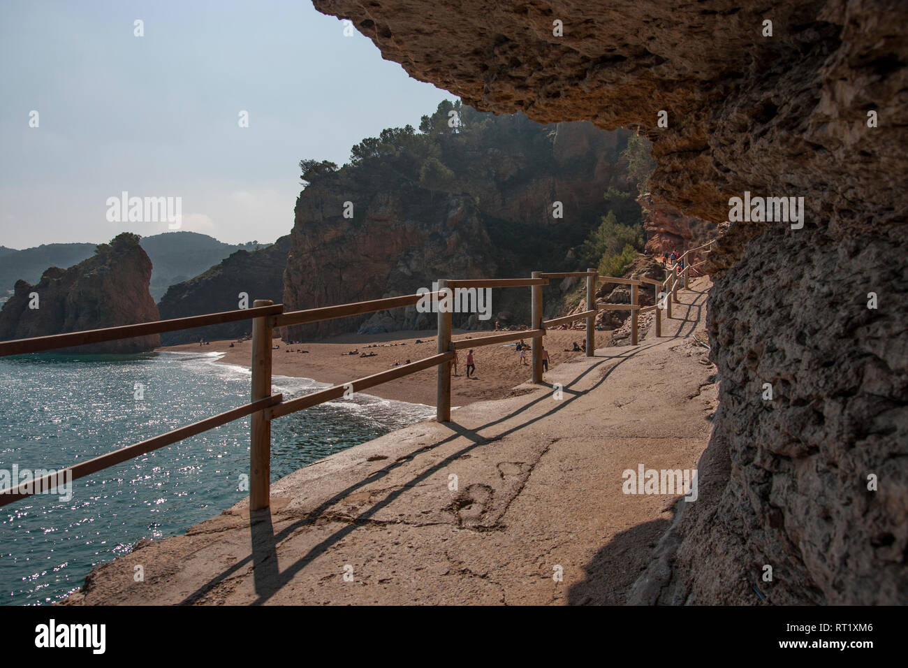 Il sentiero costiero (coast path) in Costa Brava sotto una parete rocciosa. Mare Mediterraneo, Girona, Catalogna Foto Stock