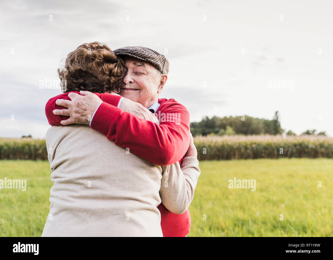 Coppia senior abbracciando nel paesaggio rurale Foto Stock