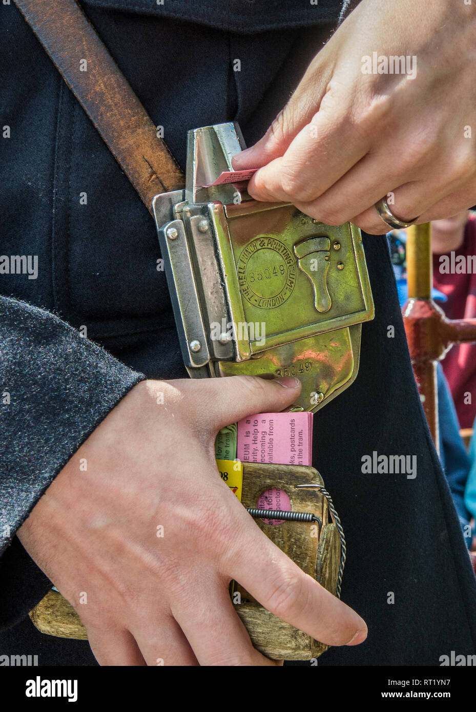Bus/tram conduttore di raccolta tariffe emissione e punzonatura biglietti su vecchia macchina Bell Punch in ottone Foto Stock