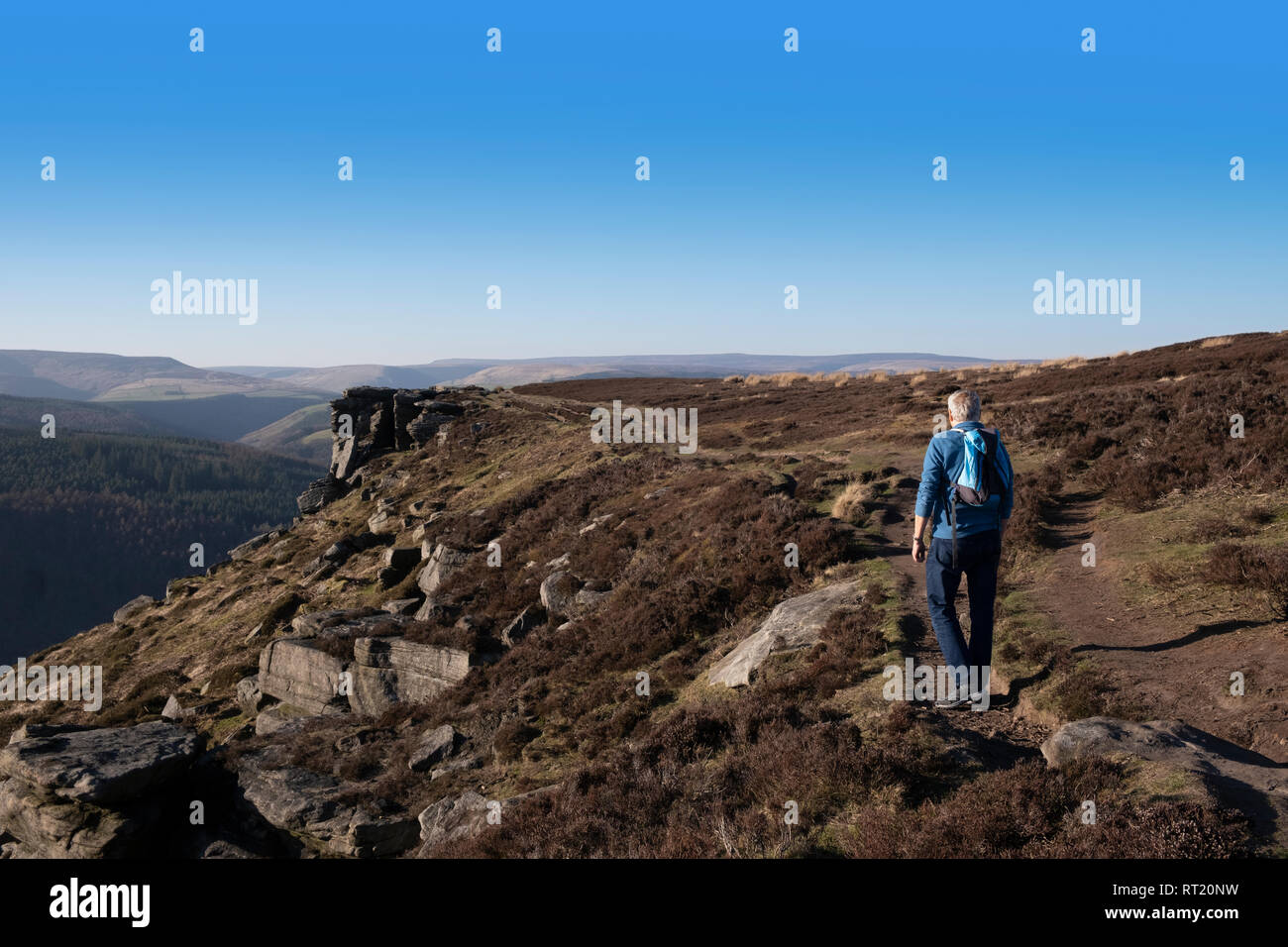 Senior maschi sani godendo di pensionamento attivo, camminando lungo il bordo Bamford nel Parco Nazionale di Peak District, UK, camminando lungo il sentiero verso la scogliera bordo. Foto Stock