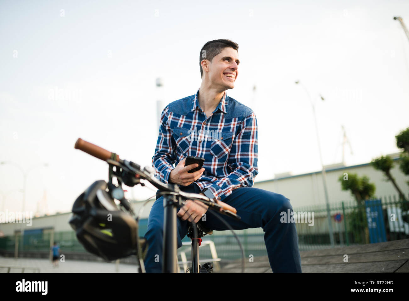 Felice giovane con bicicletta e telefono cellulare Foto Stock