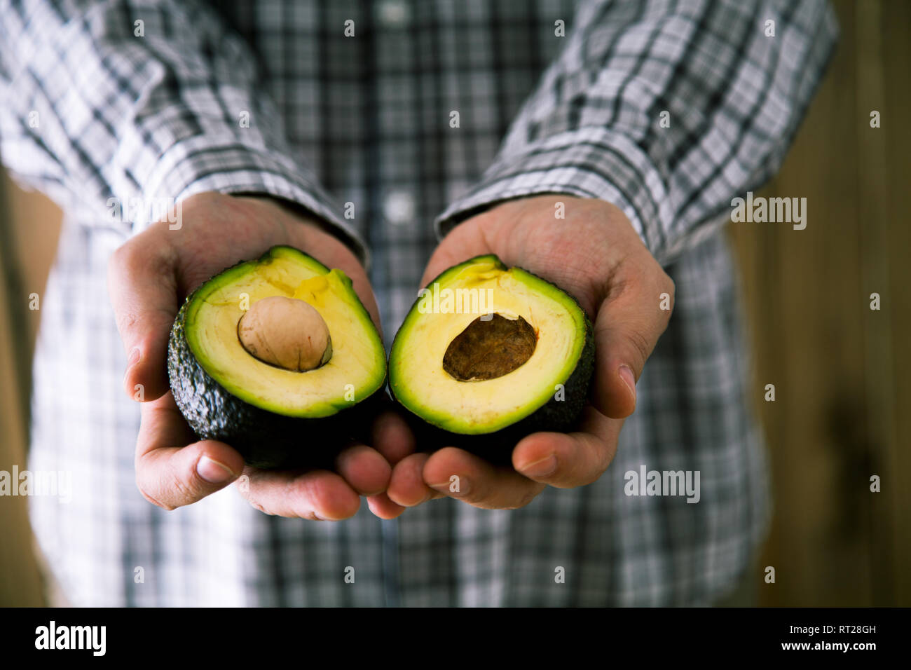 Lo chef con avocado. Uomo con fresca frutta avocado Foto Stock