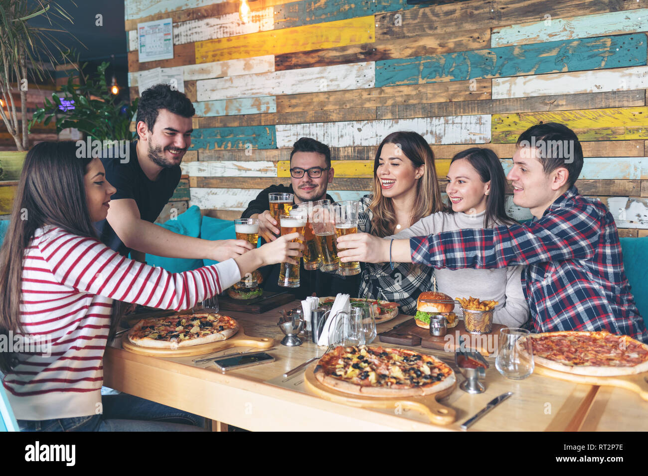 Felice giovani amici bevendo birra a parte nel pub alla moda Foto Stock
