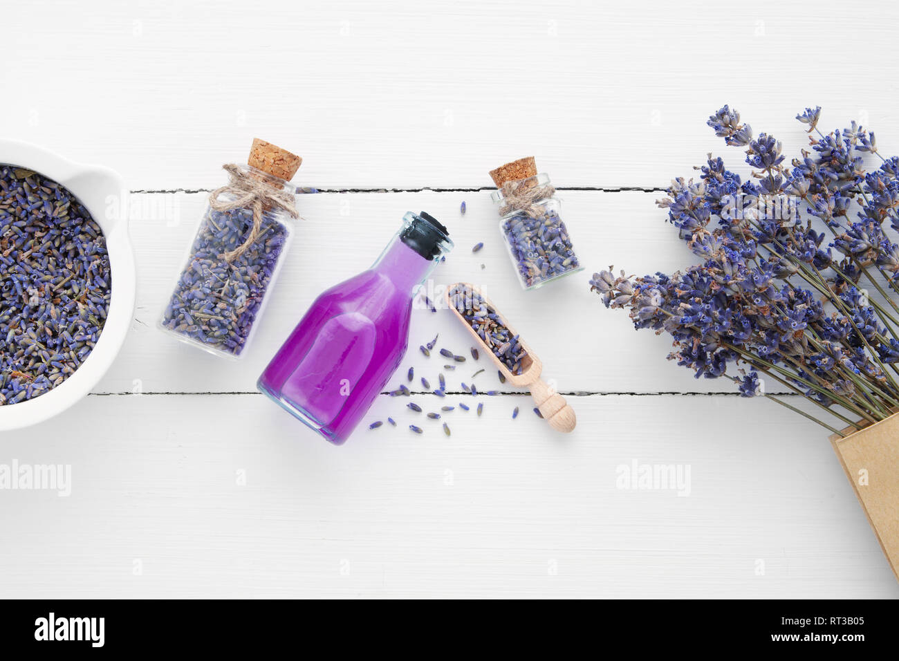 Bottiglia di olio essenziale, Malta, Lavanda fiori su fondo bianco. Vista dall'alto. Lay piatto. Foto Stock
