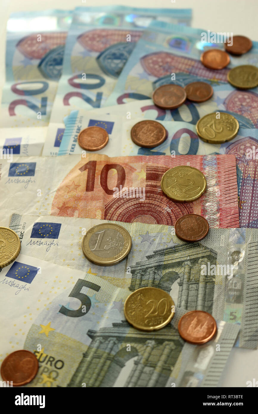 Una pila di banconote e monete in euro Foto Stock