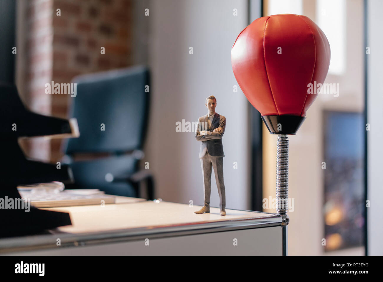 Imprenditore figurina in piedi sulla scrivania dalla sfera di punzonatura Foto Stock