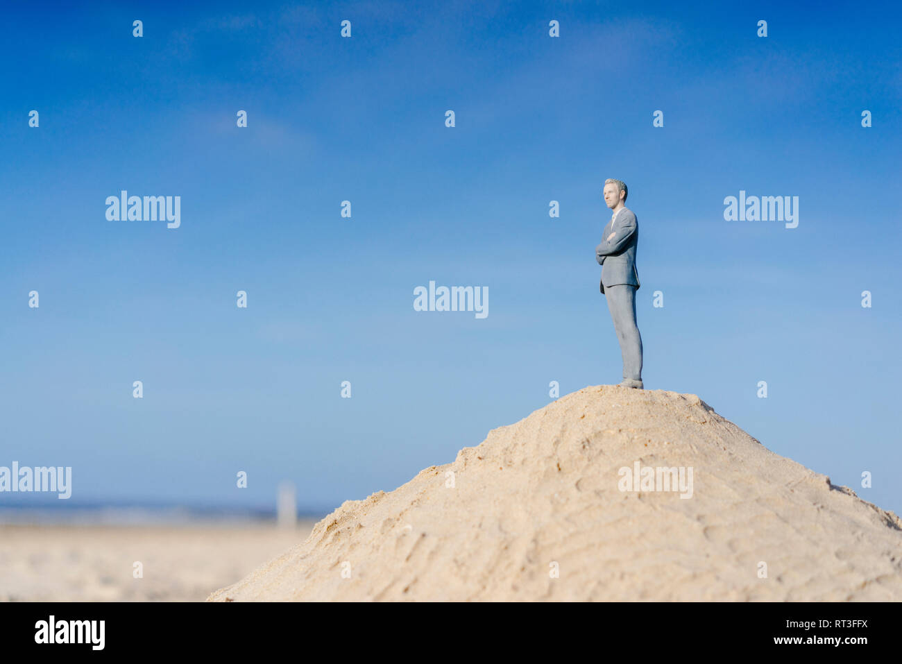 Imprenditore figurina permanente sulla Sand Hill cercando di visualizzare Foto Stock
