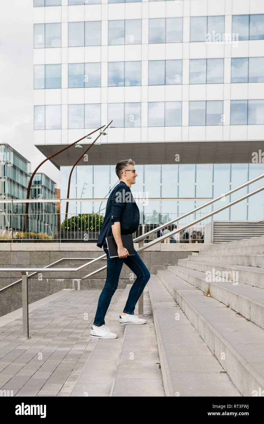 Imprenditore camminando sulle scale fuori ufficio edificio nella città Foto Stock