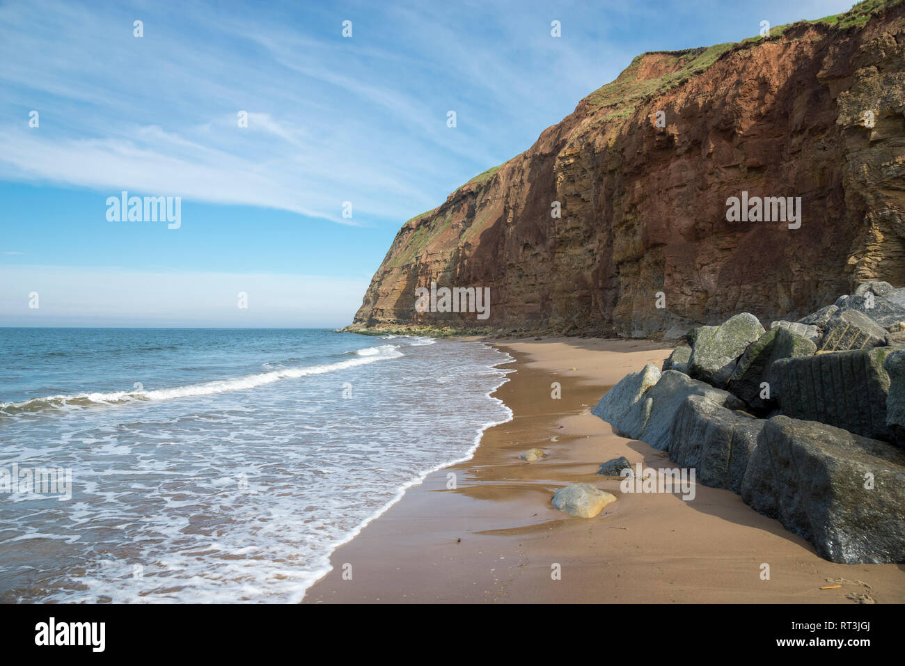 Spiaggia di sabbia e alte scogliere a Skinningrove sulla costa del North Yorkshire, Inghilterra. Parte del modo di Cleveland. Foto Stock