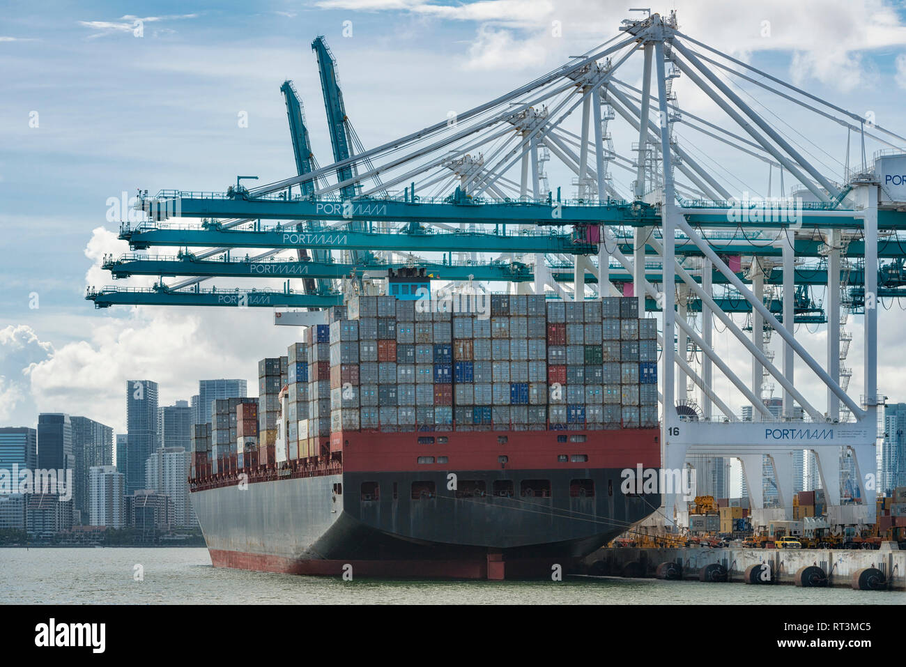 Stati Uniti d'America, Florida, Miami, Downtown, contenitore di nave con gru e skyline con alta sorge nel centro cittadino di Miami visto dall'acqua Foto Stock