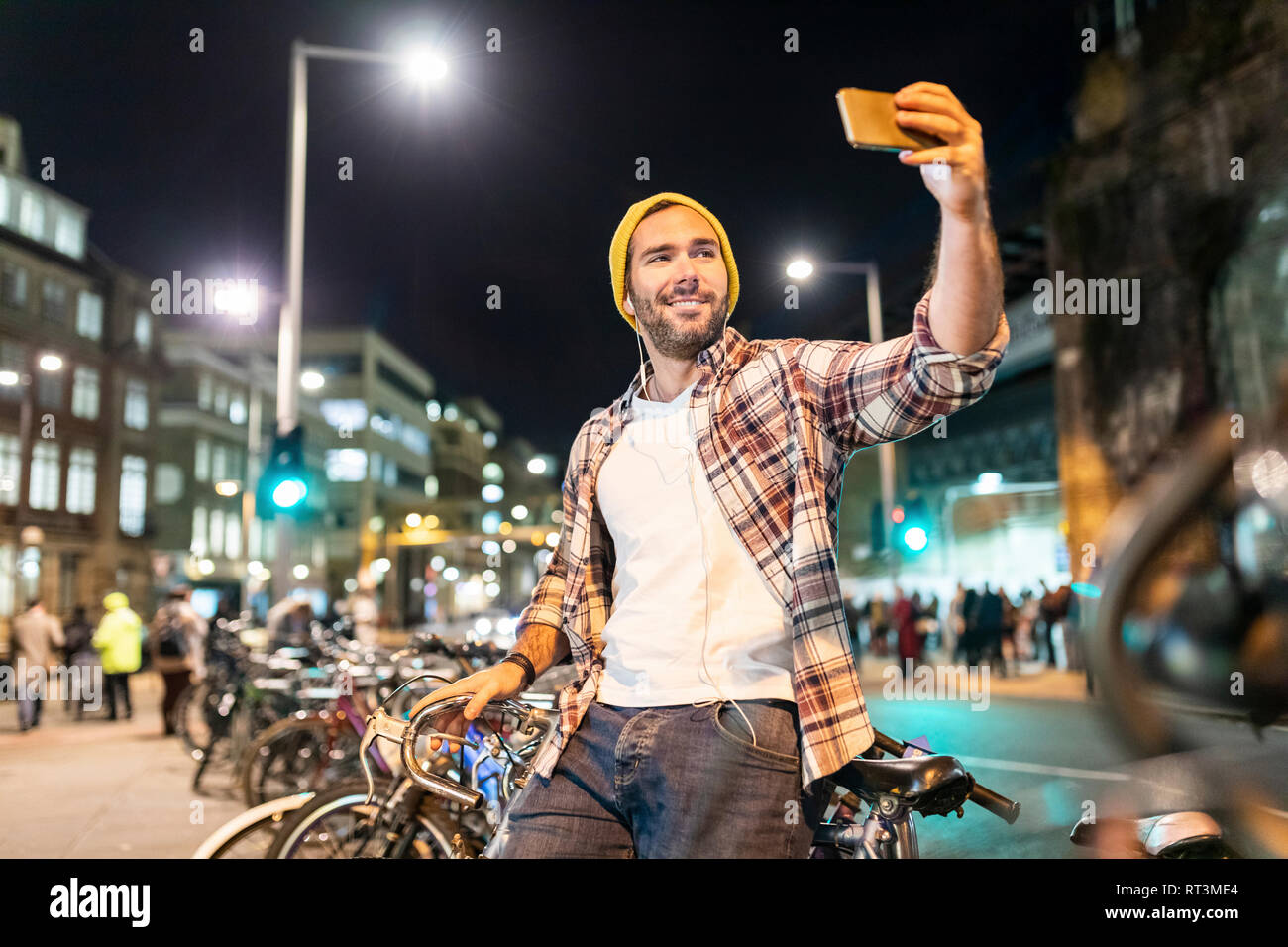 UK, Londra, uomo prendendo un selfie durante gli spostamenti di notte nella città Foto Stock
