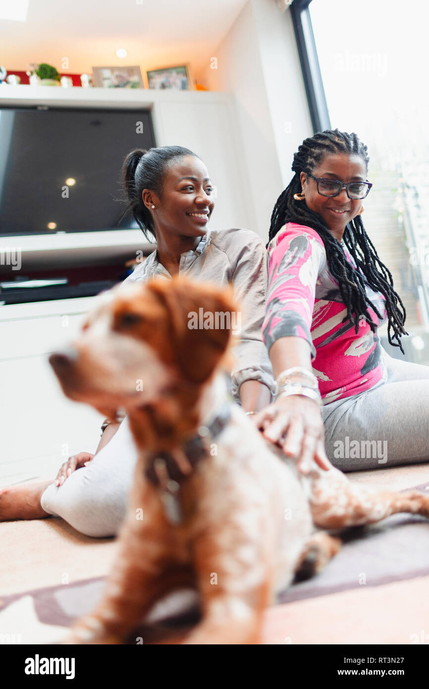 Madre e figlia adulta con il cane a vivere il pavimento della camera Foto Stock