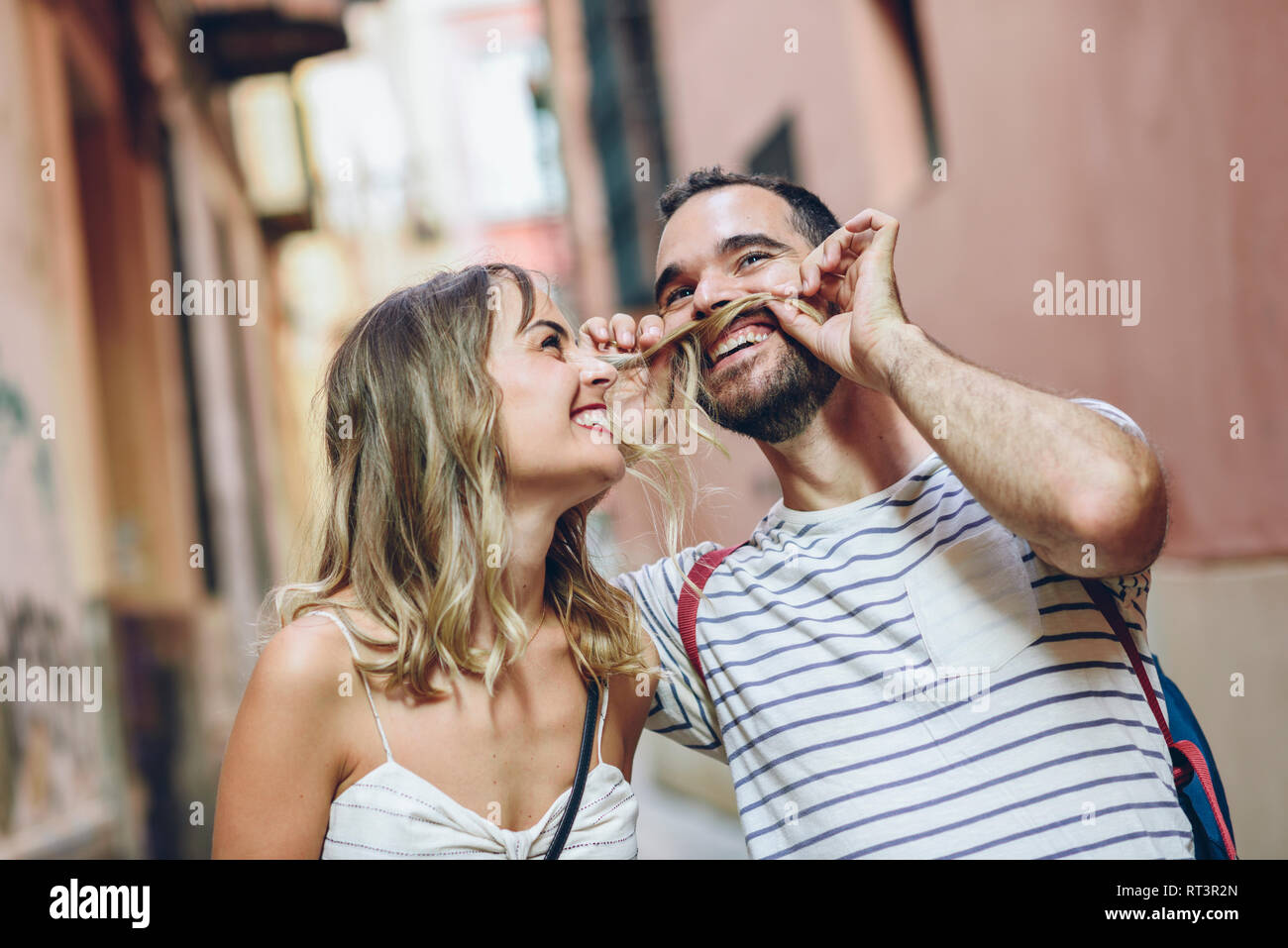 Spagna, Andalusia, Malaga, funny man mettendo la sua fidanzata i capelli come i suoi baffi Foto Stock