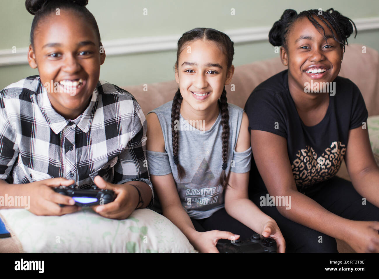 Ritratto sorridente ragazza tween amici la riproduzione del video gioco sul divano Foto Stock