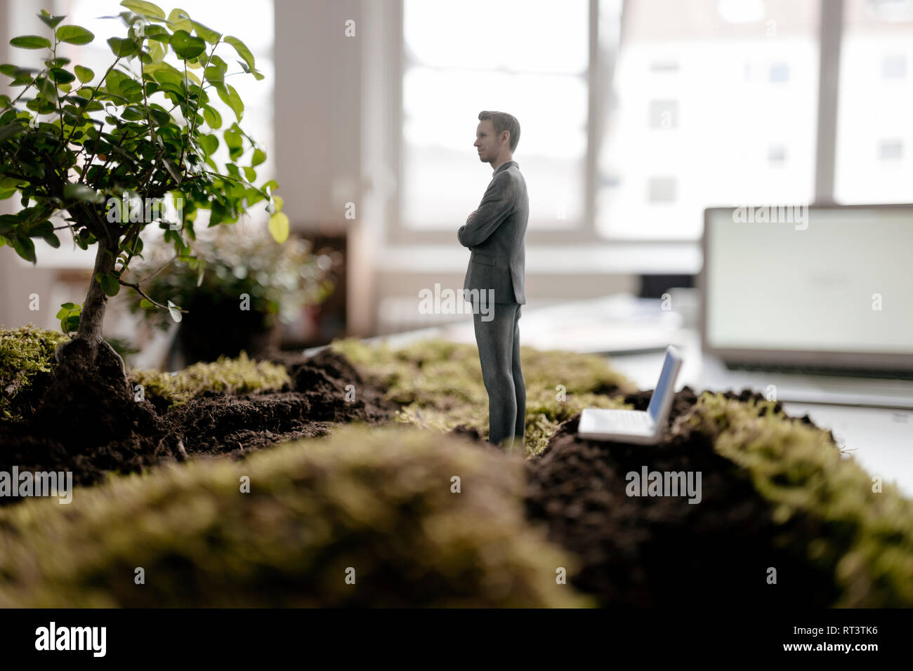 Imprenditore figurina con il computer portatile in piedi sul verde muschio Foto Stock