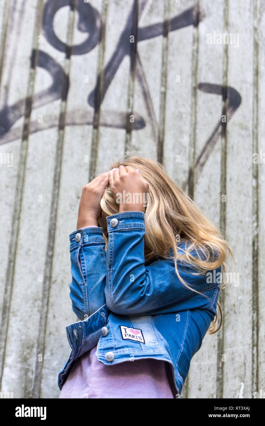 Ragazza bionda nasconde il suo volto Foto Stock